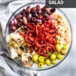 A bowl of olives, beans, sun dried tomatoes, and aritchokes