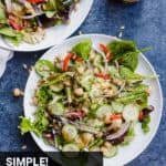 two italian chopped salads on plates with a jar of dressing