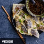 vegetable potstickers on a plate with chopsticks and dipping sauce