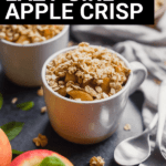 mugs of lazy girl apple crisp, some spoons, some granola, and some apples